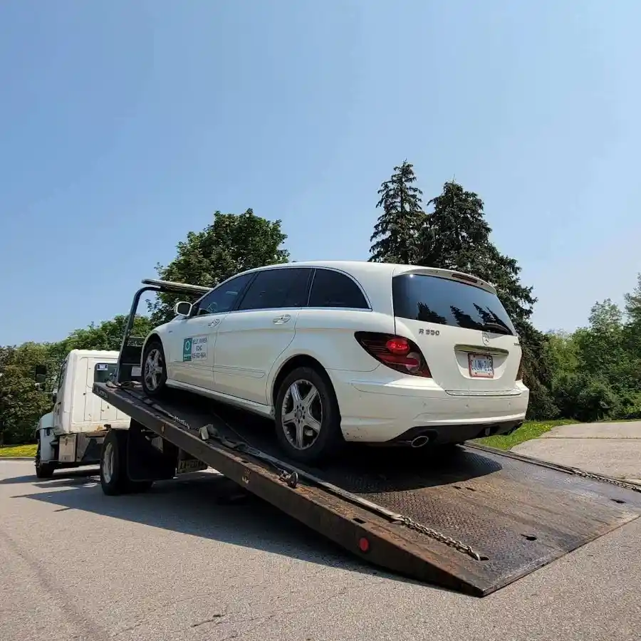 Calgary flatbed tow truck loading a white car for safe transport