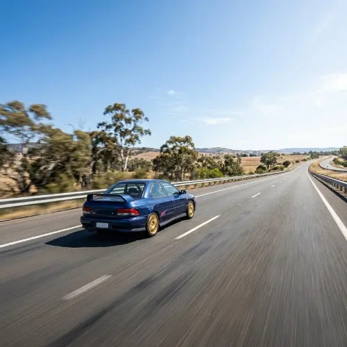 Fast blue car on rural highway needing tow truck Calgary service.