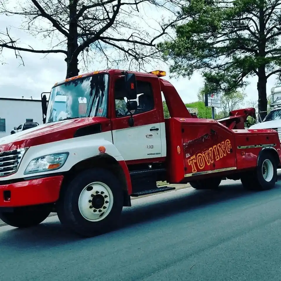 Red and white professional tow truck with towing sign on urban street Tow Truck Calgary