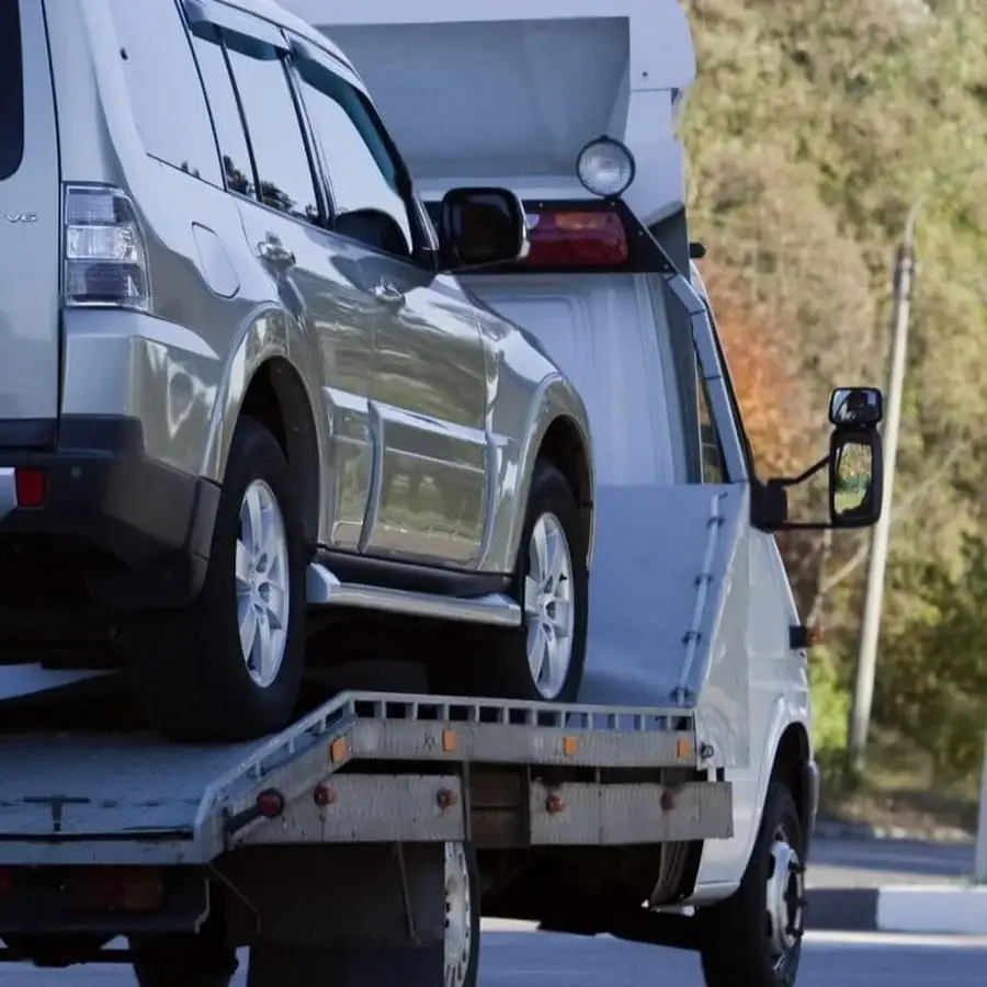 Tow Truck Calgary flatbed towing service safely loading SUV on hydraulic ramp