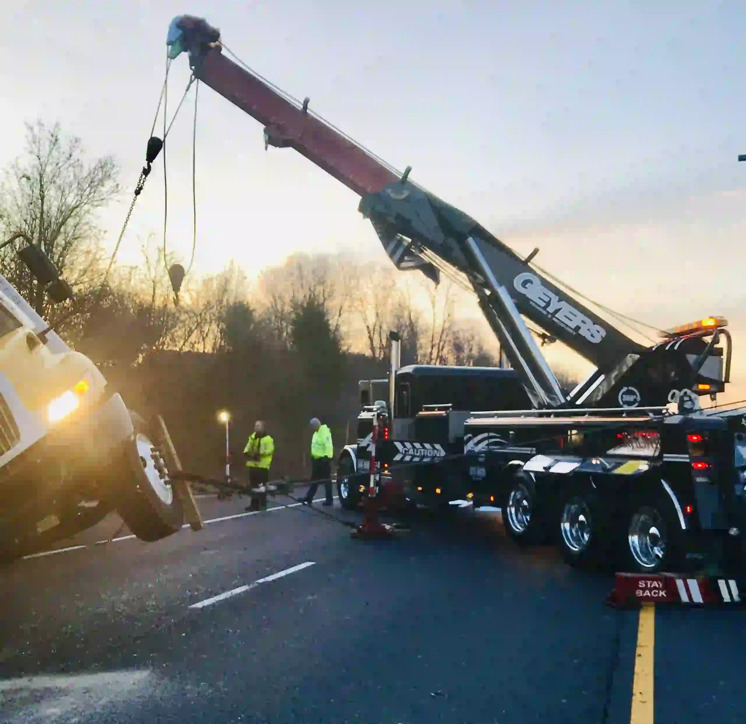Heavy-duty tow truck crane lifting overturned vehicle during accident recovery service in Calgary by Tow Truck Calgary.