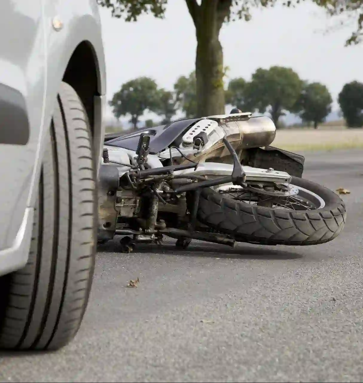 Motorcycle accident recovery scene with crashed bike on road Tow Truck Calgary.