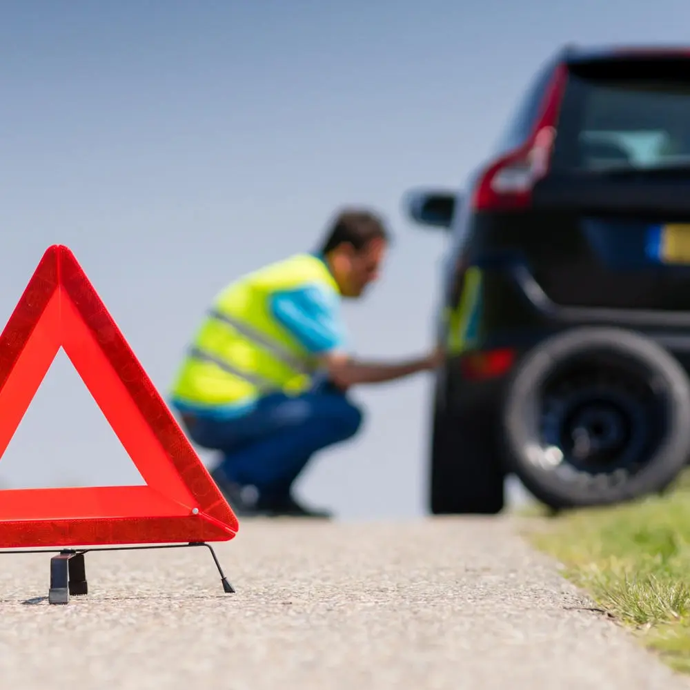 Technician placing warning triangle for roadside emergency safety in Calgary