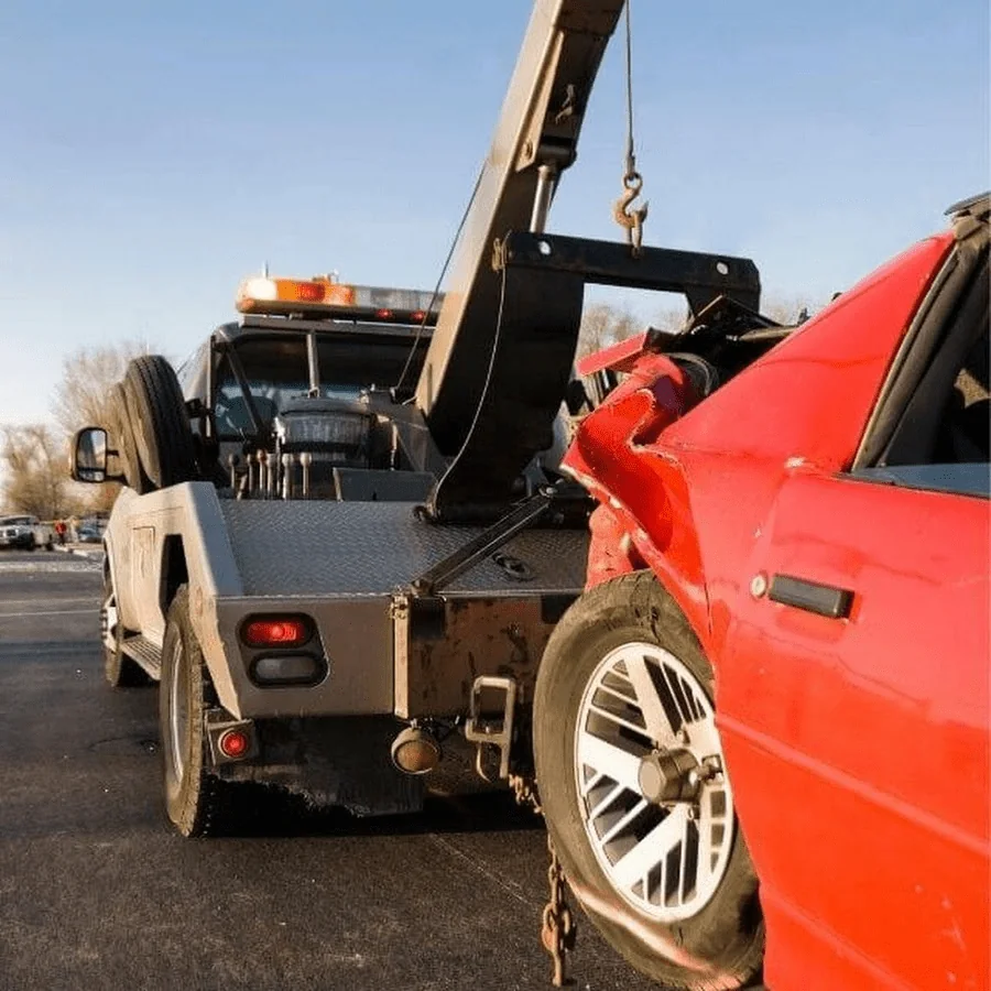 Tow truck hooking and removing damaged junk car from parking lot Tow Truck Calgary.