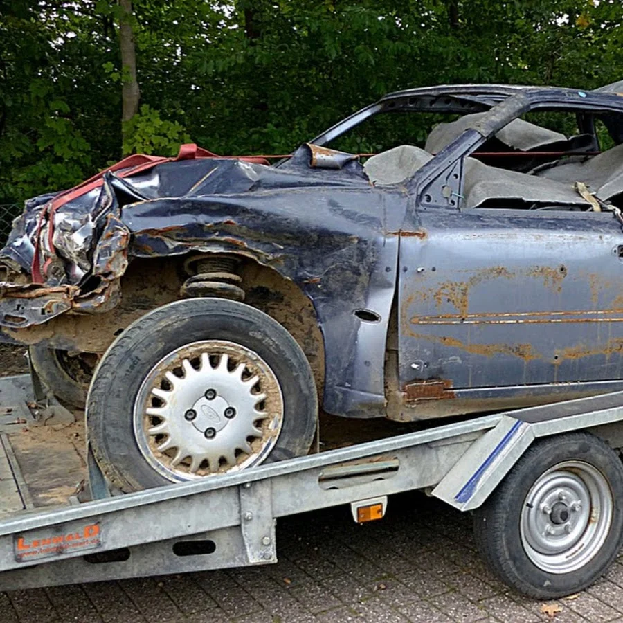 Totaled wrecked car loaded on flatbed trailer for accident recovery Tow Truck Calgary.