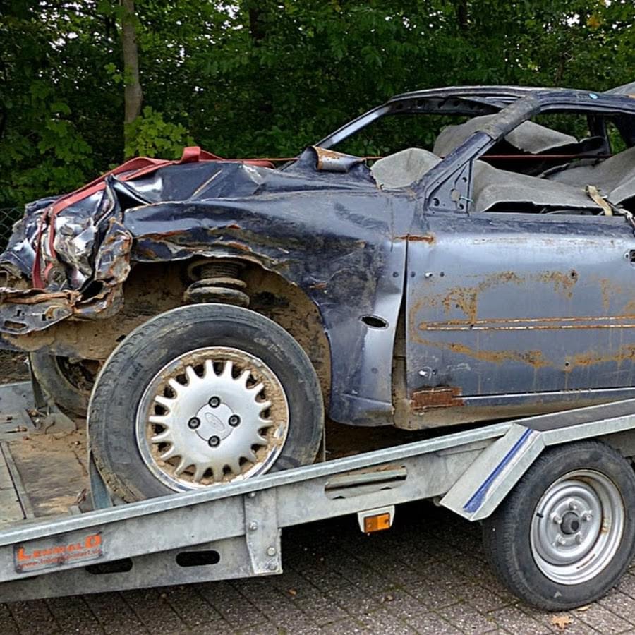 Totaled wrecked car loaded on flatbed trailer for accident recovery Tow Truck Calgary.